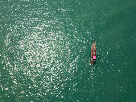 Drone shot above wooden sailboats anchored near a tropical island coastline, picturesque seaside scene featuring boats on blue water close to the shoreline beach. Exotic landscape.の写真素材