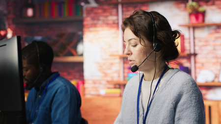 Call center agent helping customers regain access to accounts, resetting passwords. Employee in customer center workspace assisting clients needing help, providing helpful solutions, camera Aの写真素材