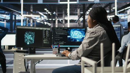 Data center computer scientist using artificial intelligence deep learning models to configure hardware. IT specialist using AI programming languages on PC in server farm, optimizing system, camera Aの写真素材
