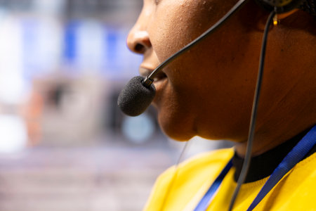 African american technician in smart manufacturing plant wears handsfree headset, overseeing...