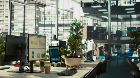 Financial charts and KPI metrics on displays in office, panning shot. Vibrant and collaborative modern workspace with computer screens displaying data analytics, panning shotの写真素材