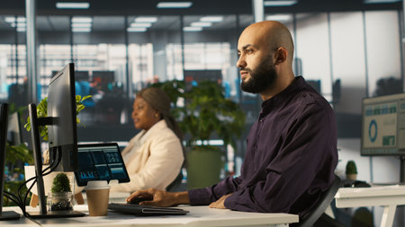 Arab man in office reviewing financial graphs, analyzing key performance indicators. Middle Eastern...