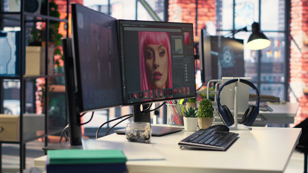 Modern office workspace equipped for digital design and photo editing. Screens show advanced editing...