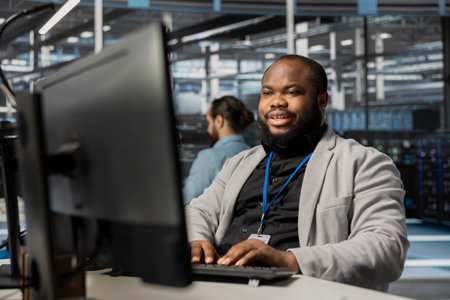 Cheerful data center employee working to update rackmounts software, configuring network...