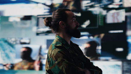 Young veteran reviewing battlefield data in a high tech command center, ensuring war planning through tactics and geopolitics details. Modern military environment focused on protection. Camera A.の写真素材
