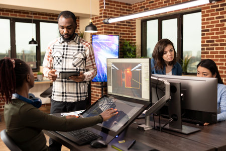 Multiethnic colleagues utilizing digital technology during their creative brainstorming session in...