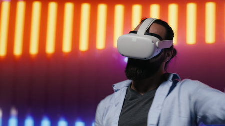 Modern man in a neon lit night scene using VR high tech glasses, embodying cyberpunk style and digital inspiration through artistic vision. Glowing reflections of futuristic aesthetics. Camera A.の写真素材