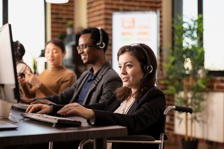 Smiling female employee wearing wired headphones works attentively at the office desk. Caucasian...