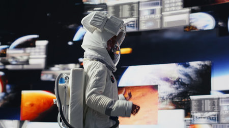 Curious astronaut standing on a distant planet in space suit and helmet, collecting samples beneath the sky filled with stars. Exploring alien worlds and cosmic frontiers in a space craft. Camera A.の写真素材