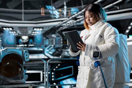 Cosmonaut looks at interface showing orbital path, preparing for planetary mission outside. Astronaut analyzing starship hardware logs, beginning landing procedures on solar system planetの写真素材