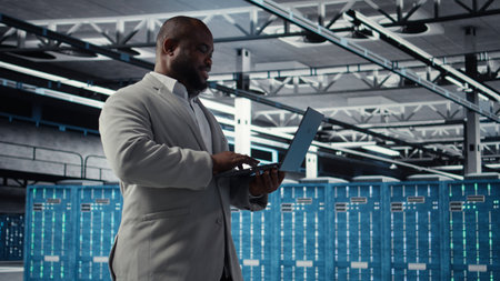 Server farm IT specialist using laptop to improve deep learning AI systems workloads. Data center...