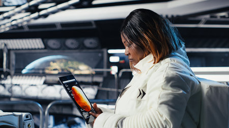 Astronaut using tablet to check analytics after completing red planet surface mission on unfamiliar planet. Cosmonaut leaving Mars, inputting navigation coordinates on device to return homeの写真素材