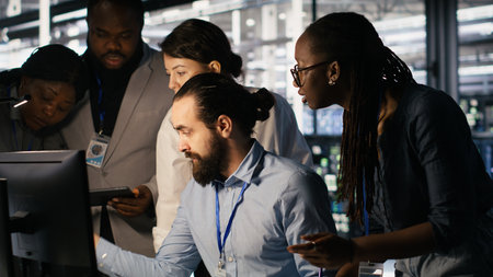Admins doing brainstorming in server hub, reviewing machine learning code and LLM visualization dashboards. Data center IT experts using computer to monitor AI infrastructure performance, camera Aの写真素材
