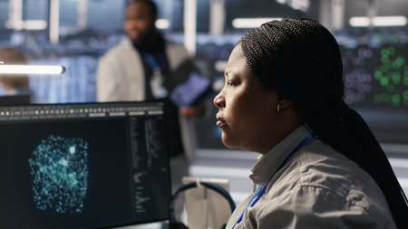 Data center system administrator using PC to monitor neural network AI visualization. African...
