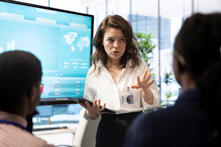 Staff members and shareholders gathering for a reports analysis in boardroom, studying infographics on interactive board and discussing potential growth opportunities. Financial projections.の写真素材