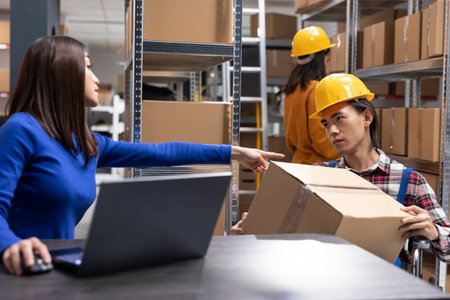 Wheelchair user working in a small business retail warehouse, managing packages and shipping tasks. Inclusive startup supporting local delivery with logistics and product handling stations.の写真素材