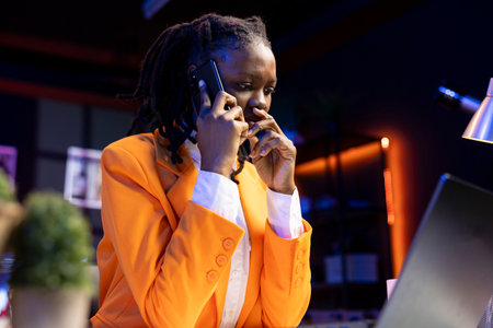 Concerned woman in phone call with friend hearing bad news, consoling him. Worried african american teenager speaking with upset mate after receiving troublesome telephone call at homeの写真素材