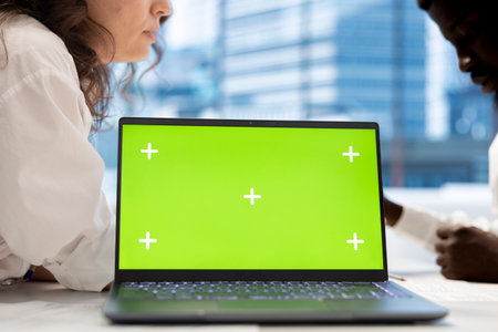 HR coworkers using green screen laptop to do preemployment assessments and background checks to potential job applicants. Headhunters use chroma key notebook to attract qualified candidatesの写真素材