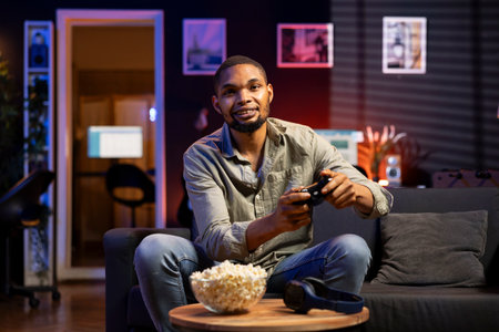 Focused young adult participates in online shooter video games at home, having fun with gaming...
