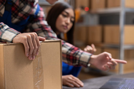 Home business employees preparing products and boxes for local delivery, supply room. Asian team work on efficient order processing and express shipment for a growing local brand.の写真素材