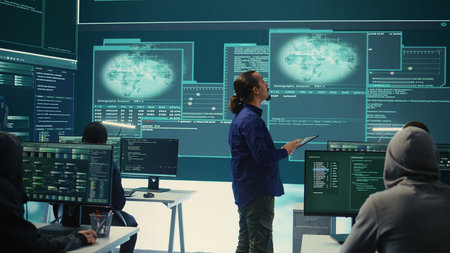 Group of professional hackers gaining access into government database to steal important information for hybrid warfare. Experts work on scams and phishing activity in high tech office. Camera B.の写真素材