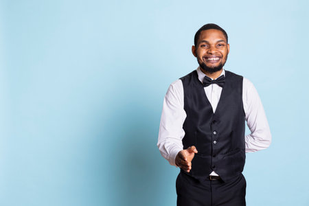 Bellboy receptionist welcoming hotel guests at the five star resort, smiling and greeting clients at...