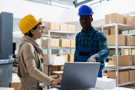 Storehouse diverse employees managing stock and inventory for distribution, shelving units and organized storage of parcels. Employees manage delivery systems for order accuracy and flow.の写真素材