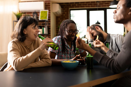 Diverse friends talking, laughing and sharing snacks and beer during casual hangout in brick wall...