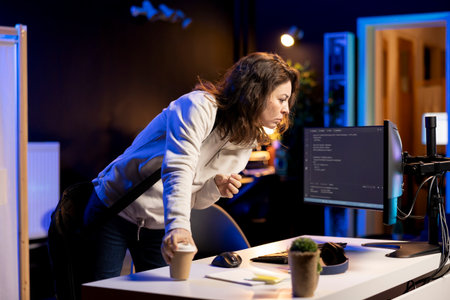 System administrator with disposable cup of coffee entering office to implement security measures, protecting company systems and data. IT expert starting job shift with hot beverage, testing codeの写真素材
