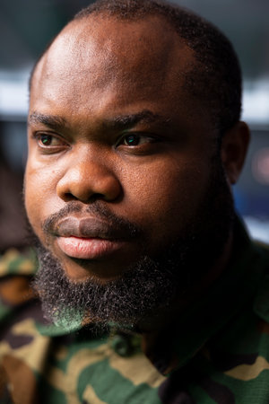 Focus on military operative deploying electronic warfare tools to disrupt enemy communication systems. African american soldier operating on high tech infrastructure, close upの写真素材