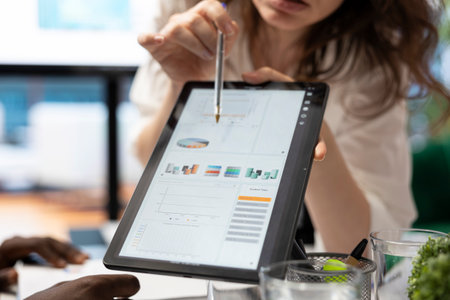 Management team studying monthly infographics on interactive board, looking into market supply and demands to facilitate global expansion. Forecast affiliates review reports. Close up.の写真素材