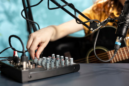 Content creator filming technology review of newly released DJ controller, unboxing it, turning buttons, knobs and sliders. Influencer showcasing sound mixer equipment to subscribersの写真素材