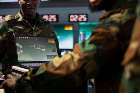Military officers operating aerial systems on laptop device to support reconnaissance and target...