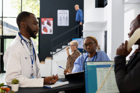 Black healthcare workers conducting a planning session in the hospital lobby, focused on teamwork and professional career development. Delivering high quality medical services at clinic.の写真素材
