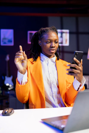 Young person checking up on close friends during phone video conference meeting over the internet. African american gen Z teenager enjoying time together with friend in online video callの写真素材