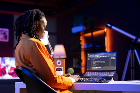 Freelancing admin in home office using laptop to write programming language code. Young software technician working from apartment using notebook device to build applicationの写真素材