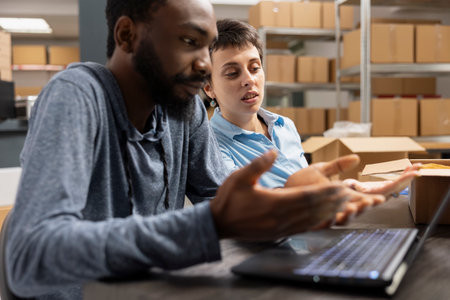 Team of diverse people checking logistics for order processing tasks and express delivery, working in a distribution hub supply room. Working on product handling for local brand.の写真素材