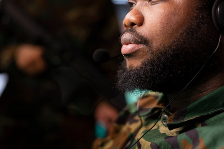 Military officer reporting battlefield information to army decision makers using headset mic. Close up of dispatcher talking with generals on call, giving enemy coordinates, tracking air movementの写真素材