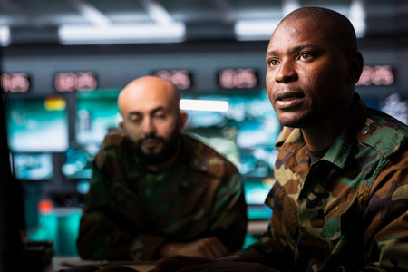 Army officers use reconnaissance gear to do threat monitoring and target recognition in command center. Military professionals employing modern warfare intelligence to help troops defeat enemiesの写真素材