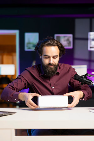 Tech content creator filming packaged product unboxing, giving reasons to purchase it. Influencer recording video urging subscribers to buy advertising sponsor merchandiseの写真素材