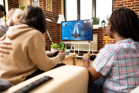 Caucasian couple on couch playing video games with african american friend during indoor hangout in...
