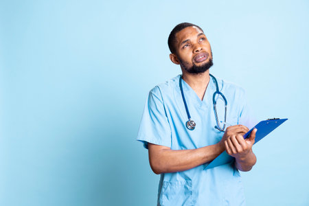 African american medical staff having the test results on clipboard papers, using the patient...
