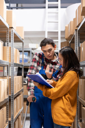 Warehouse staff member with a walking problem helps organize boxes and prepare merchandise for shipment. Inclusive logistics center for the local brand, order processing and express delivery.の写真素材