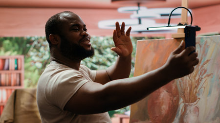 African american painter recording a video and self advertising masterpiece, using social media to...