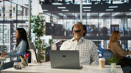 Tired overworked business manager dealing with burnout at his office desk, feeling stressed about...