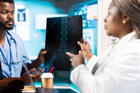 African American doctor discussing with her nurses residents to find treatment options, showcasing...