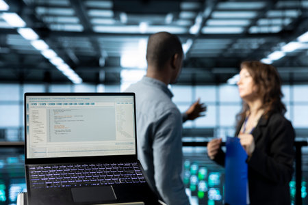 Focus on laptop in data center used by software developers refining server virtualization...