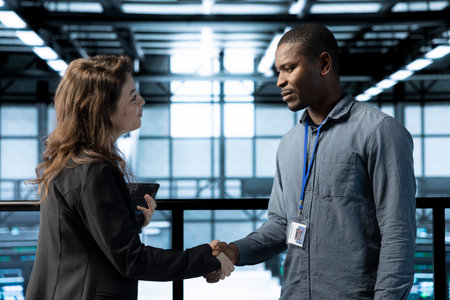 Manager meeting with computer scientist in data center, coming to inspect servers. Supervisor doing...