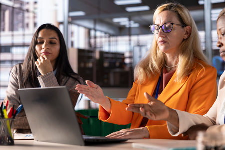Successful women leaders discuss business strategies in a financial district office, promoting...