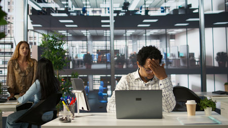 Overworked frustrated employee faces a migraine from pressure, dealing with burnout after a failure....